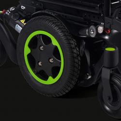 Close up image of black wheel with green rim of a powered wheelchair.