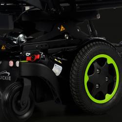 Close up image of black wheel with green rim of a powered wheelchair.