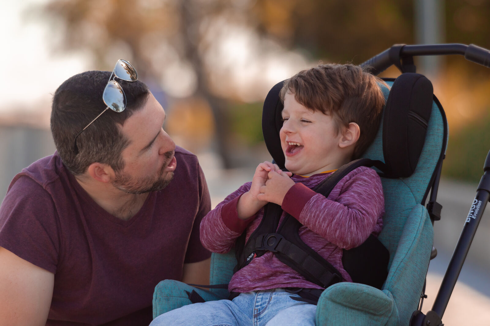 Robbie confidently seated in the Bingo Evo stroller as he smiles with his dad and enjoys the outdoors  with ergonomic support.