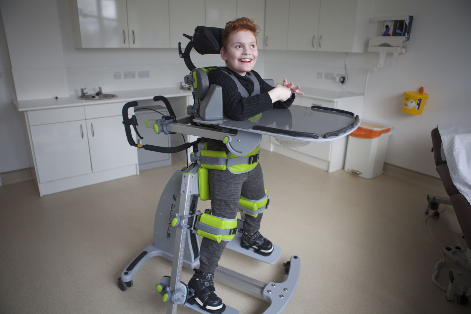 Child standing outdoors in a Jenx Standz abduction stander, showing early intervention benefits with supported standing and hip abduction.