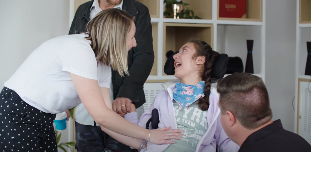 Woman and man talking to a person in a wheelchair