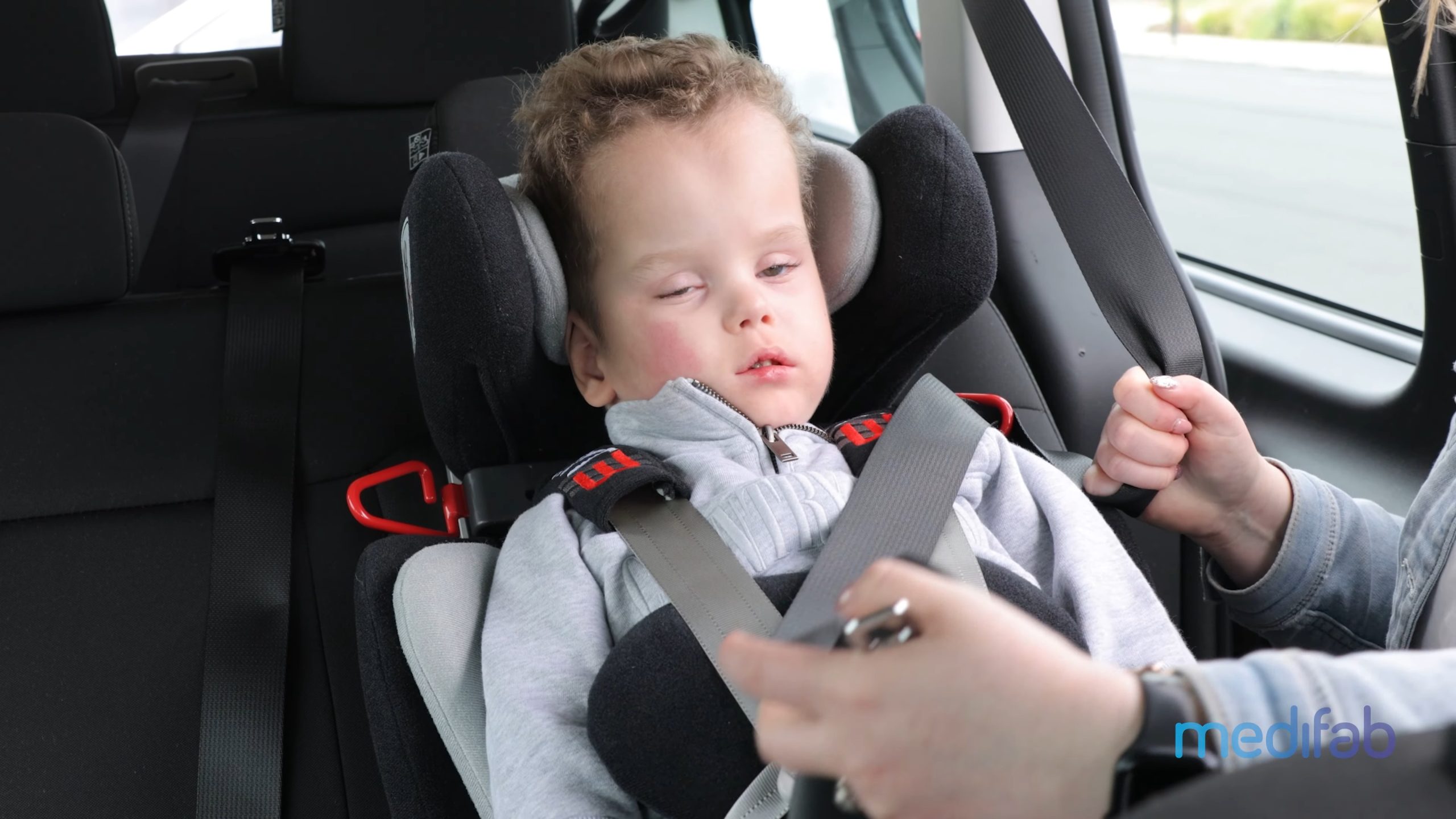 Small toddler buckled into the Carrot car seat 3000 Swivel base