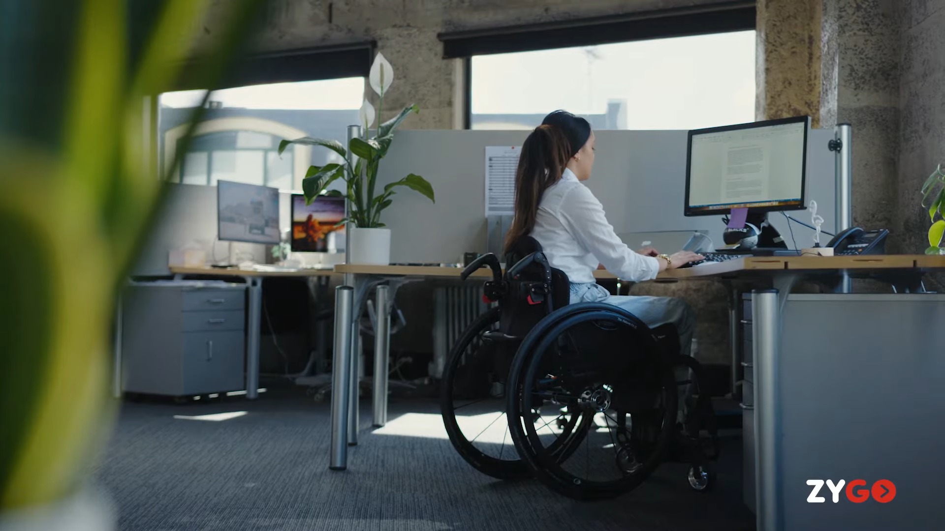 Chelsea sits in her zygo wheelchair in the office.