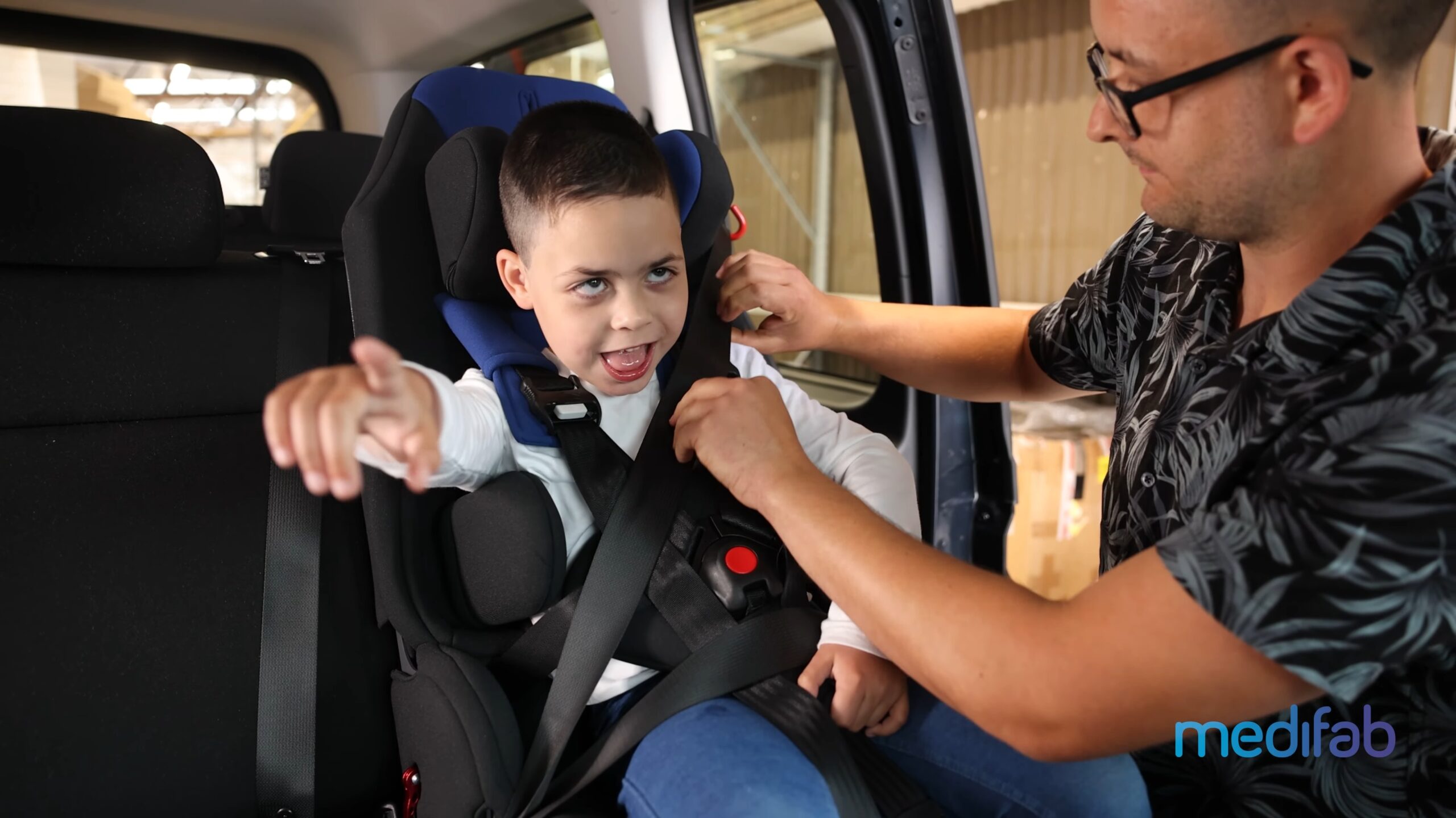 young boy happily being strapped into his Kidsflex Car Seat