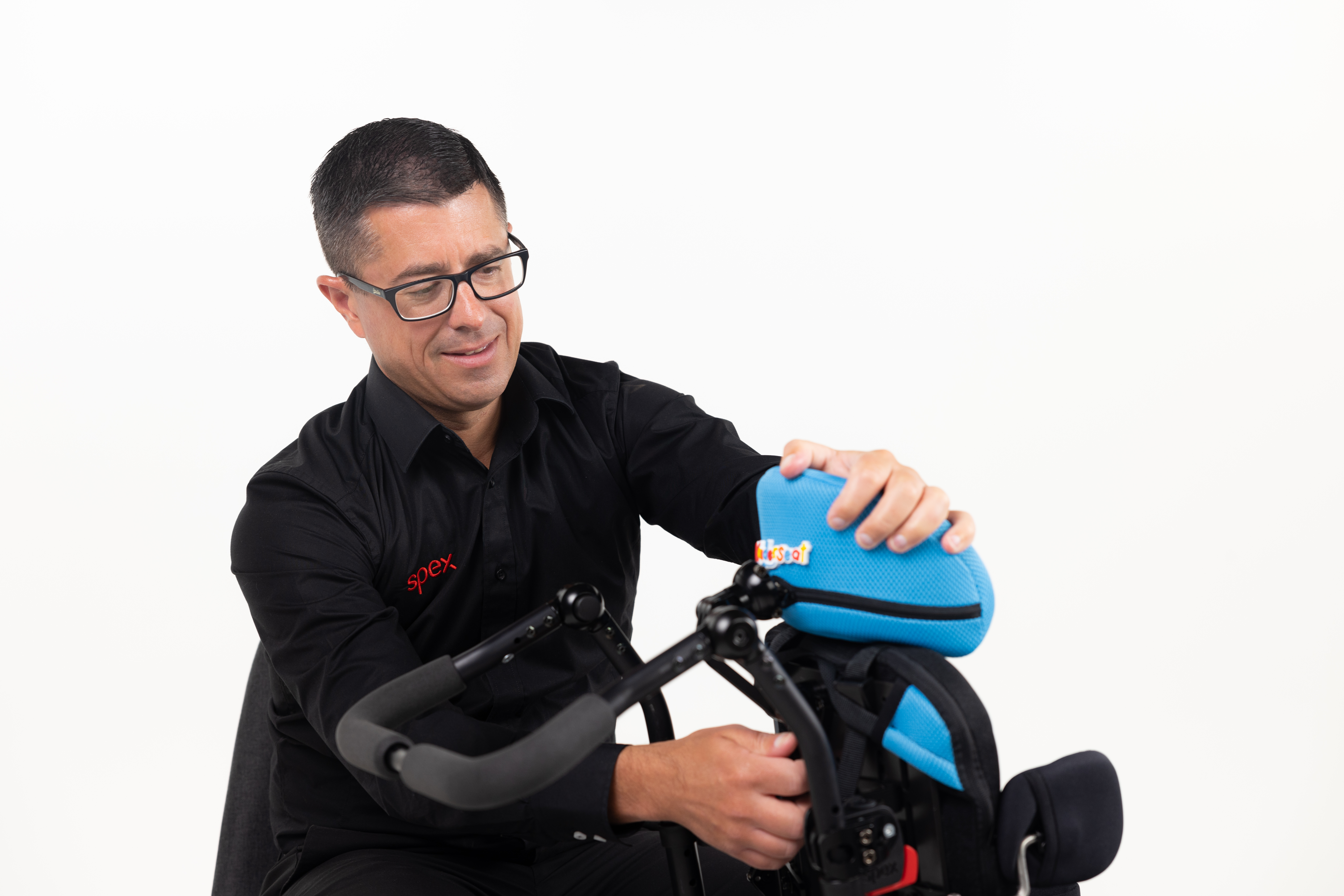 Spex General Manager Bruce Mascull adjusting a light blue Wonderseat Bounce Paediatric wheelchair backrest.